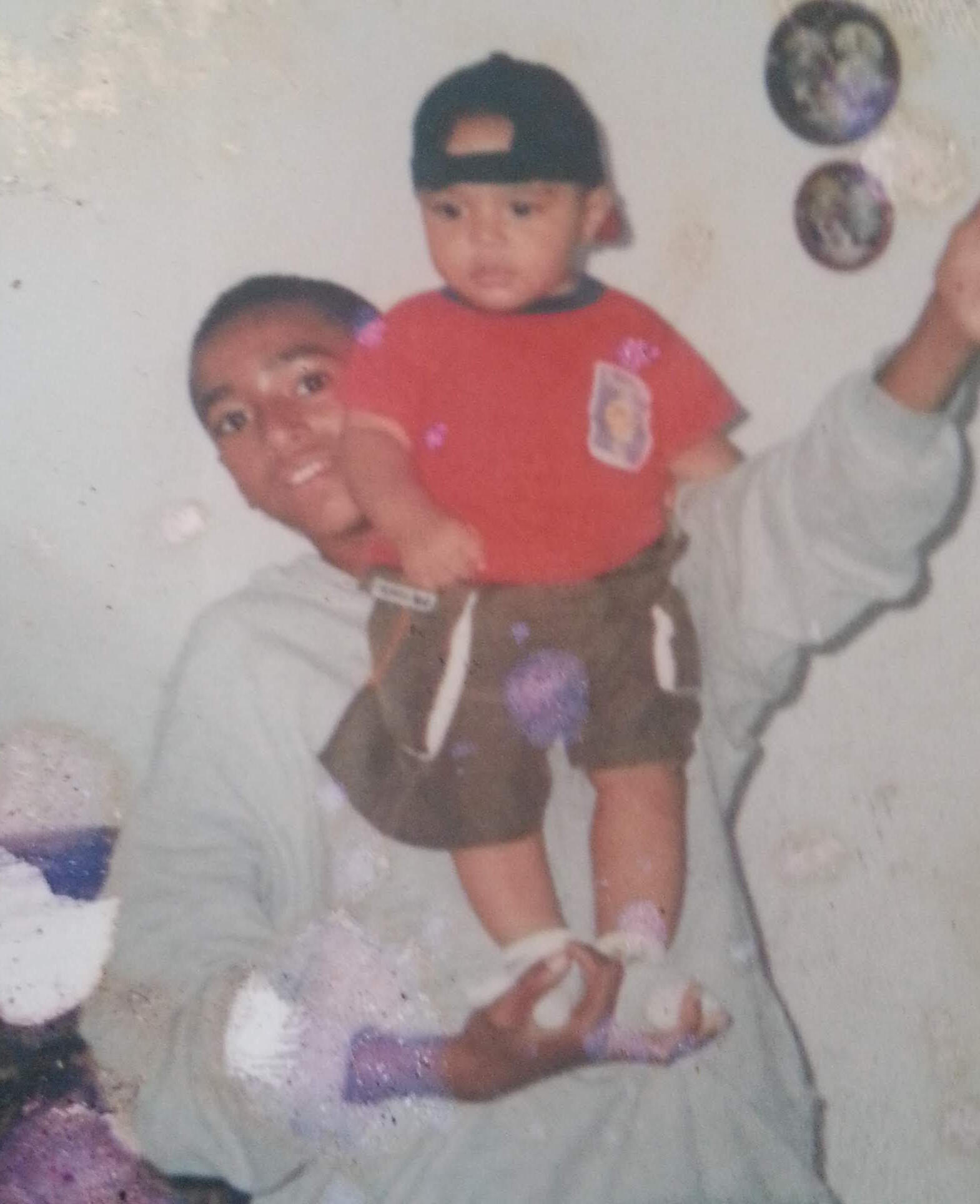 Meu irmão me segurando em uma fotográfia antiga.